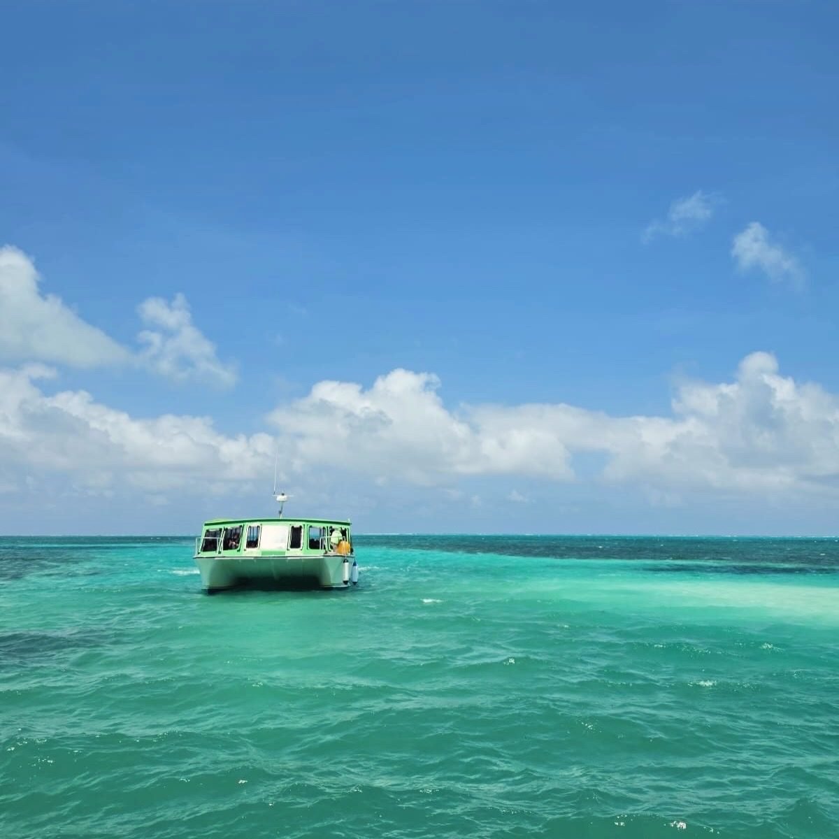 Lancha navegando sobre el arrecife de coral de Belice