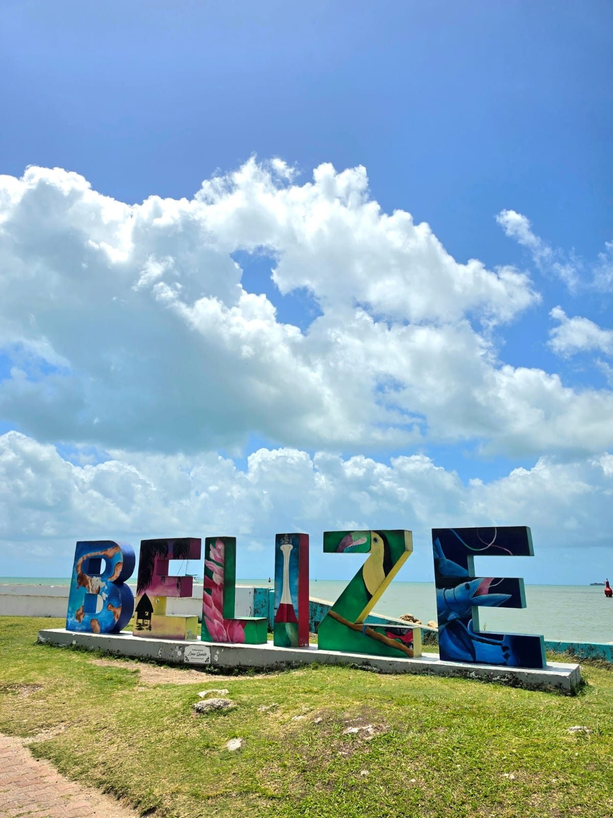 Letras coloridas de BELIZE frente al mar Caribe